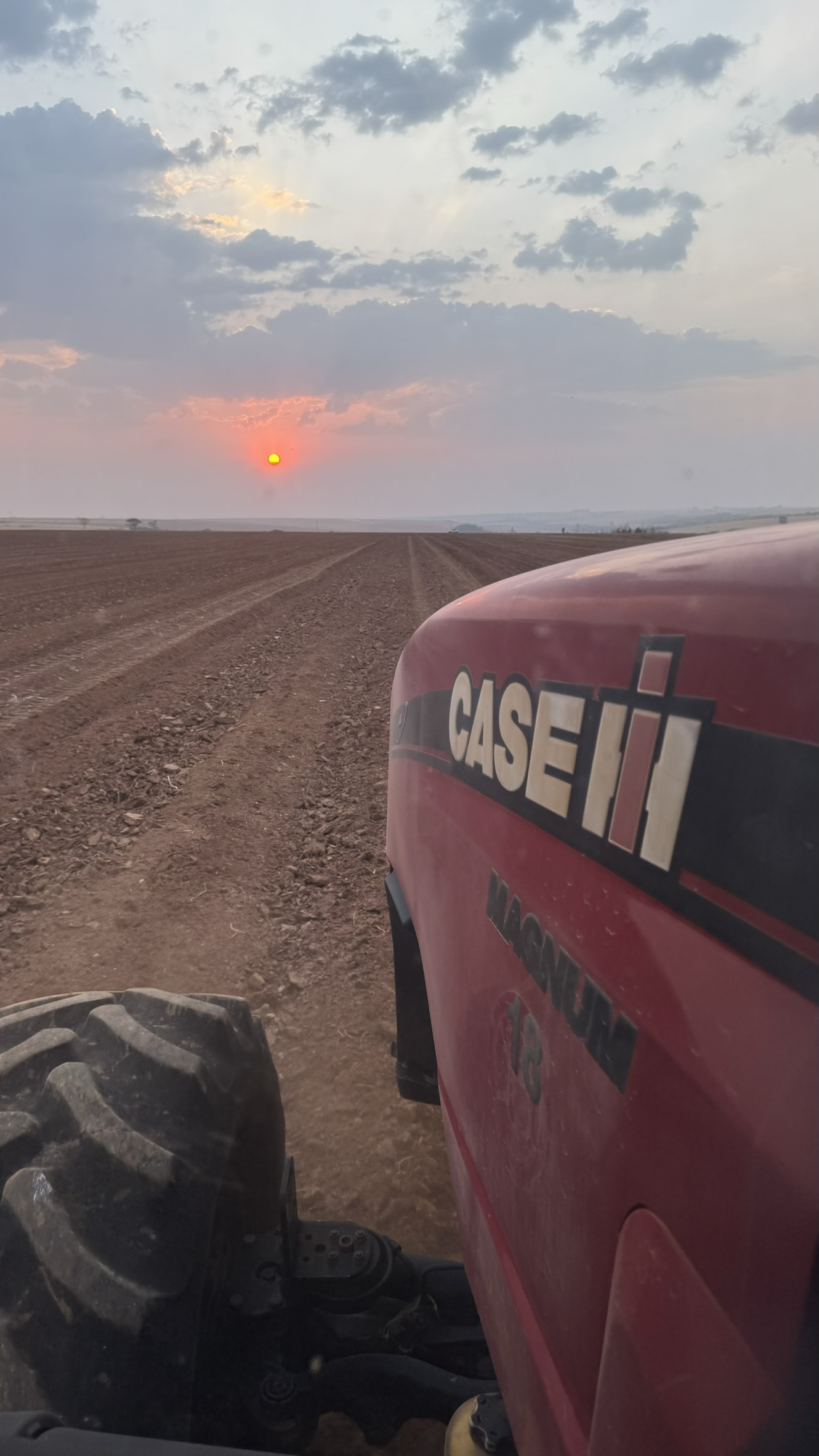 Trator Case IH Magnum ao pôr do sol na lavoura