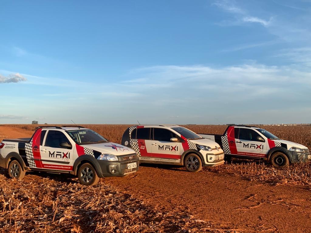 Frota de carros Maxi plotados no meio do algodoal ao entardecer